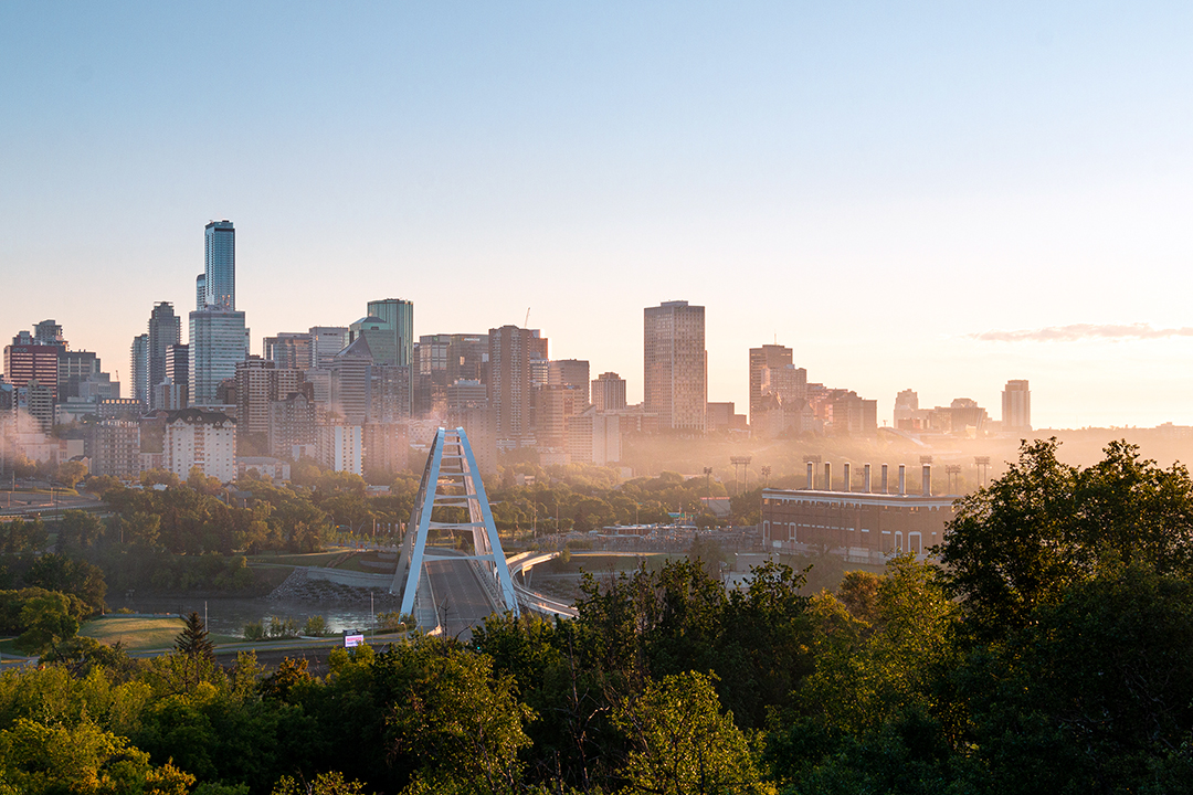 City skyline viewed across a river at sunrise.