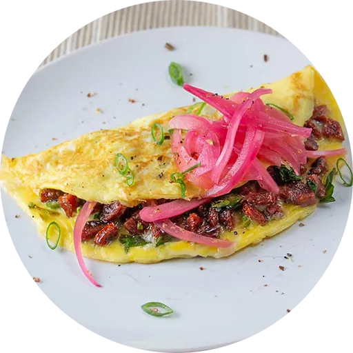 Omelette filled with a red-coloured sausage and topped with pink pickled onions.