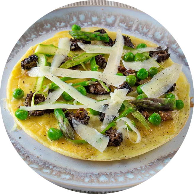 Open-faced omelette topped with morel mushrooms, asparagus, peas and white cheese.