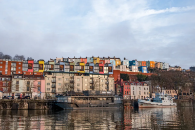 Houses painted in many different colours overlooking a river.