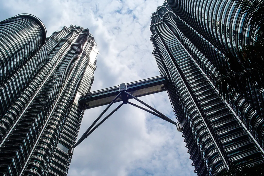 Two spiral skyscrapers with a bridge connecting them.